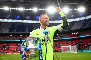 Leicester goalkeeper Kasper Schmeichel celebrates with the FA Cup trophy in 2021.