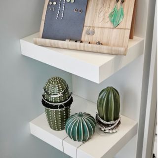 Three cactus shaped decorations on a shelf