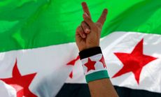 A Syrian activist flashes a peace sign during a protest against the participation of Hezbollah in the Syrian war, in Beirut, Lebanon, June 9.
