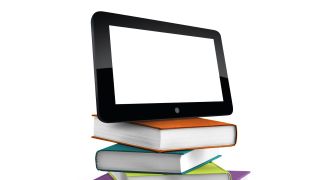 Tablet computer atop a stack of books with brightly colored covers