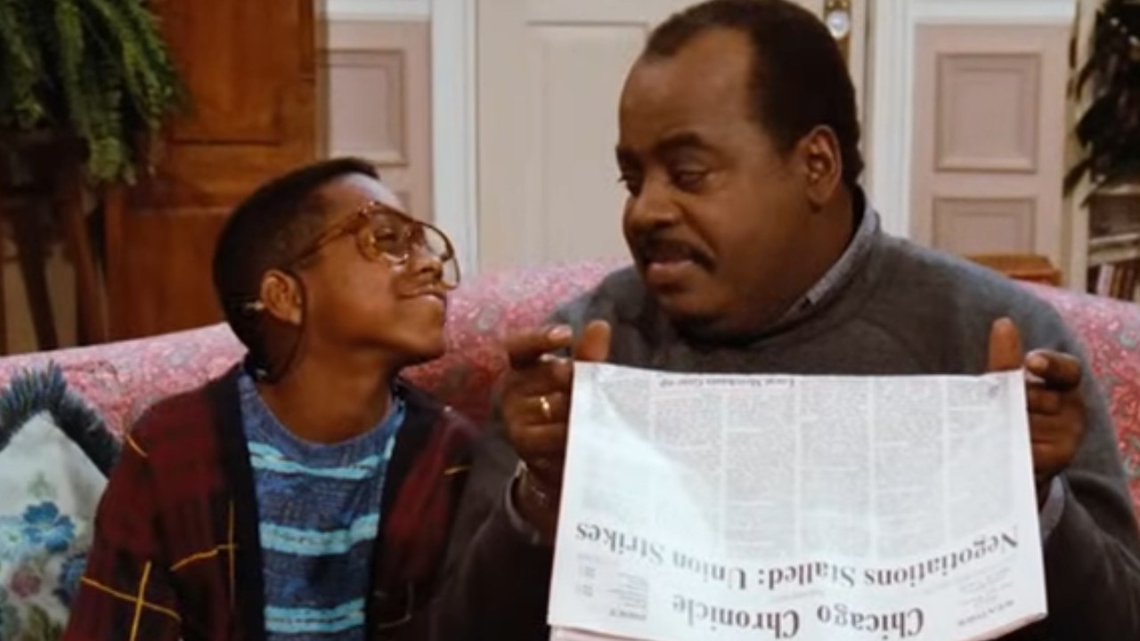 Jaleel White sitting beside Reginald VelJohnson on the couch on Family Matters