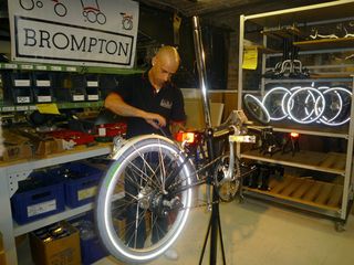 A man in bike shop working on assembling a bike together.
