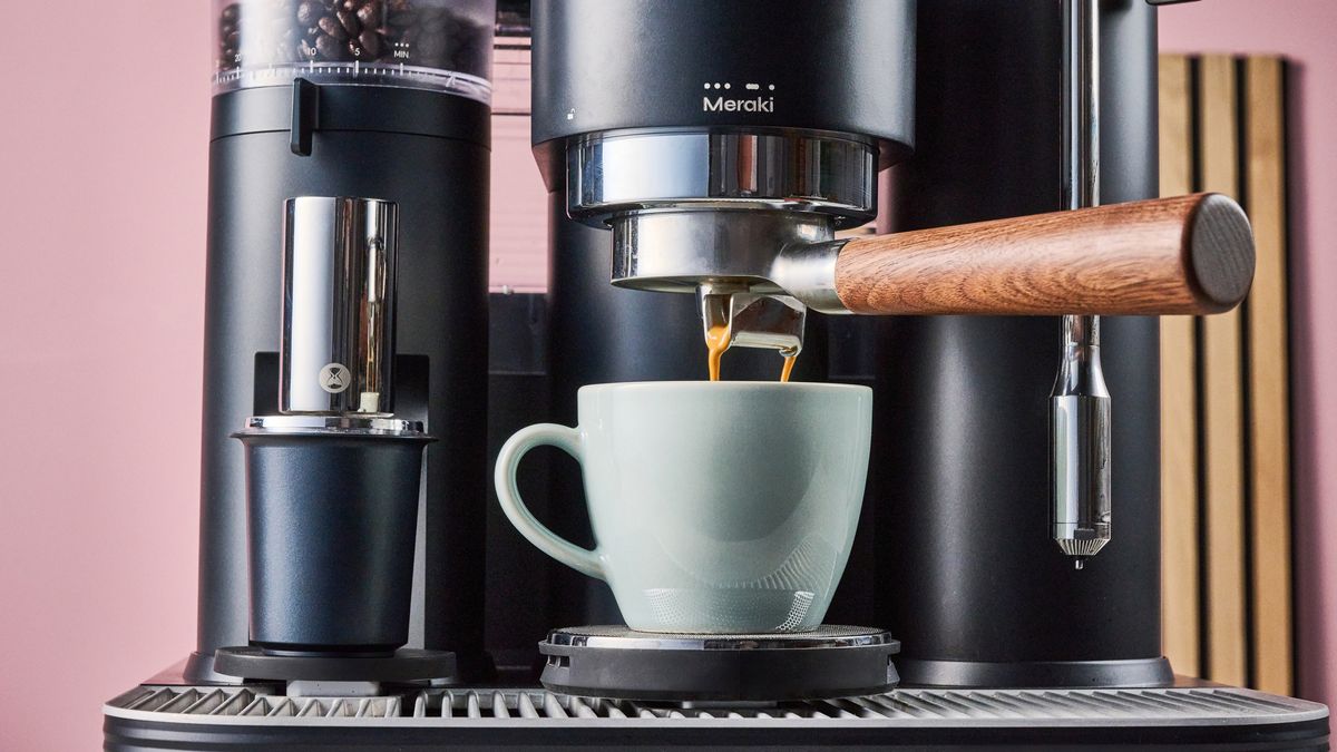 A closeup of the Meraki Espresso Machine pouring espresso into a turquoise mug.