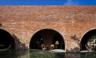 The structure is a series of 24 symmetrical red brick arches built into a quadrangle