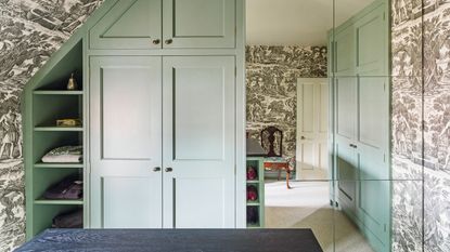 Dressing room with black toile wallpaper and green wardrobes