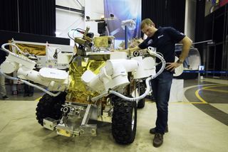 ESA astronaut Andreas Mogensen and the Eurobot, which is designed so that astronauts in a spaceship can control it while it's on the surface of a planet or moon. It's one of many robots already working in space.