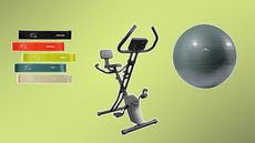 Aldi exercise bike surrounded by five vertically stacked resistance bands and a gray exercise ball on a green background fading from right to left