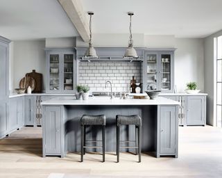 blue kitchen with and island and white subway tiles