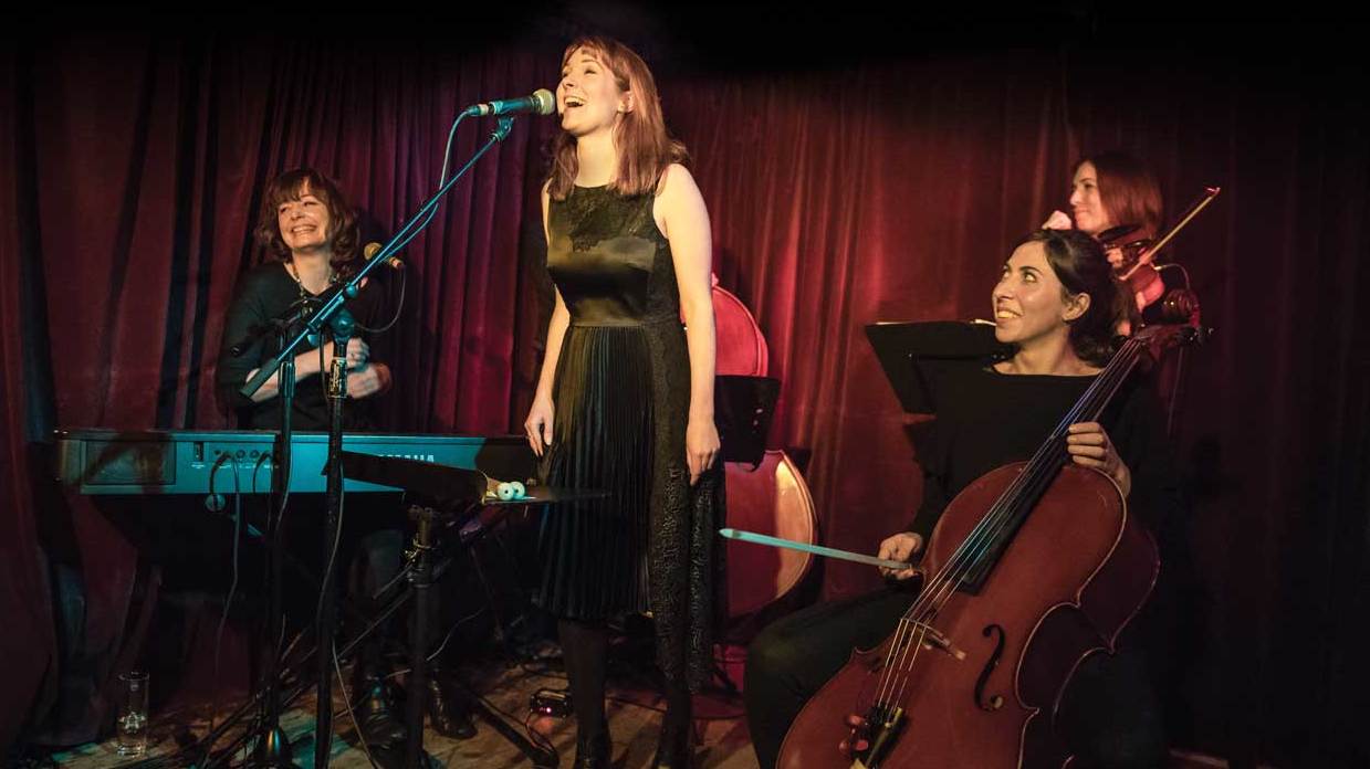 Beatrix Players laughing on stage with guest violinist