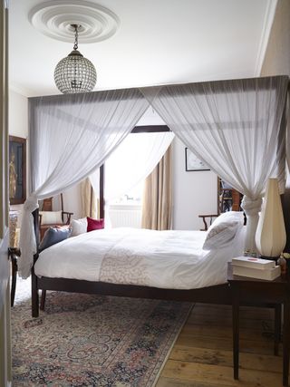 A guest room with a fourposter bed and a crystal chandelier in a Victorian rectory