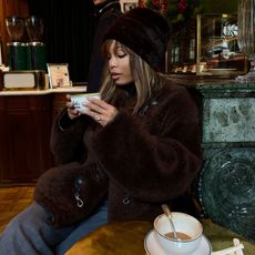 @slipintostyle outfit image toteme brown shearling coat drinking coffee