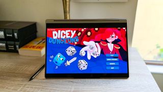 Lenovo Yoga 9i Gen 8 review unit on desk playing Dicey Dungeons