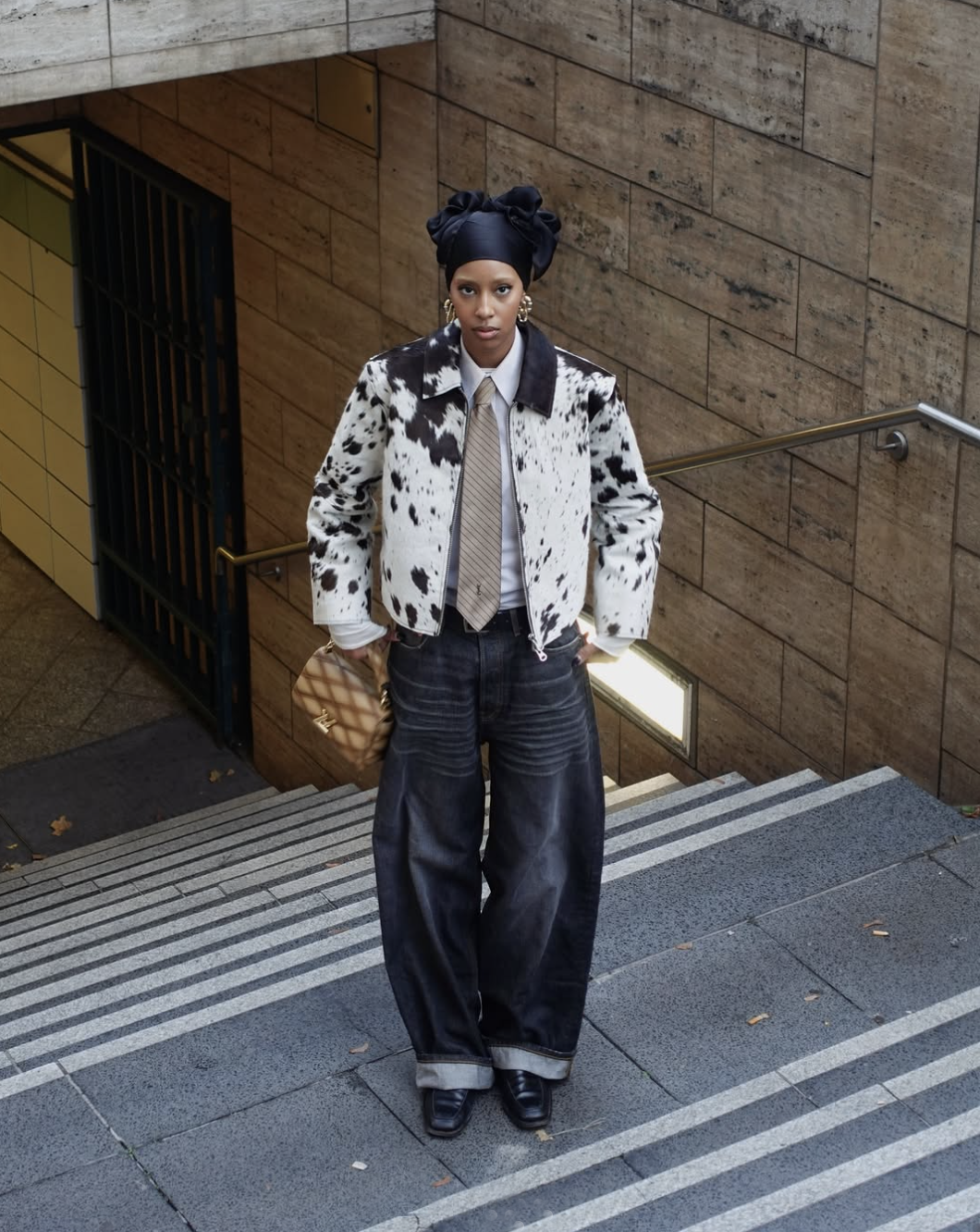 woman wearing barrel-leg jeans, a shirt and tie, and a ponyhair jacket