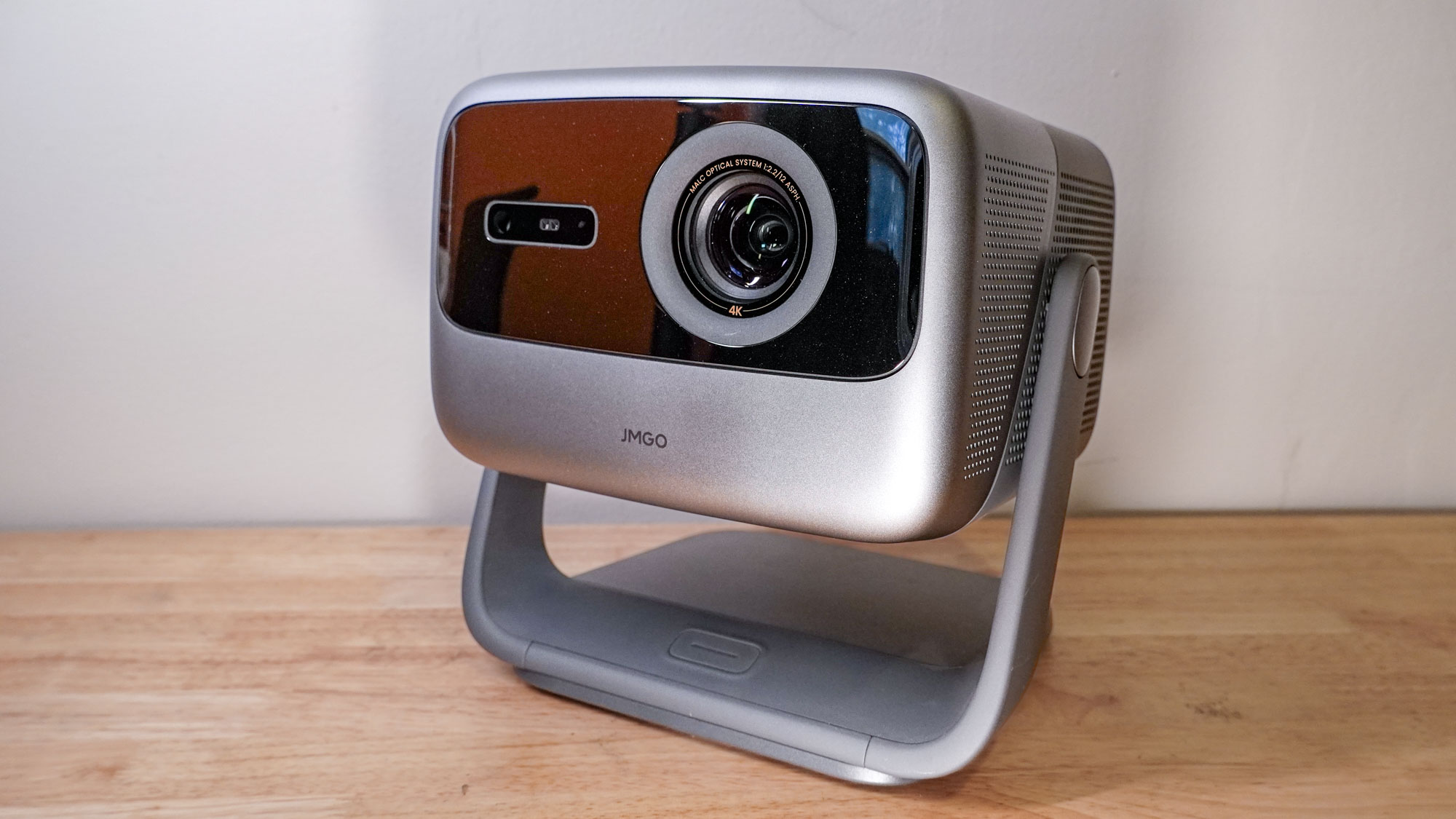 A JMGO N1S Ultimate projector on a wooden table top.
