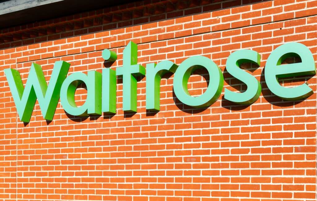The Waitrose logo on the side of a red brick wall