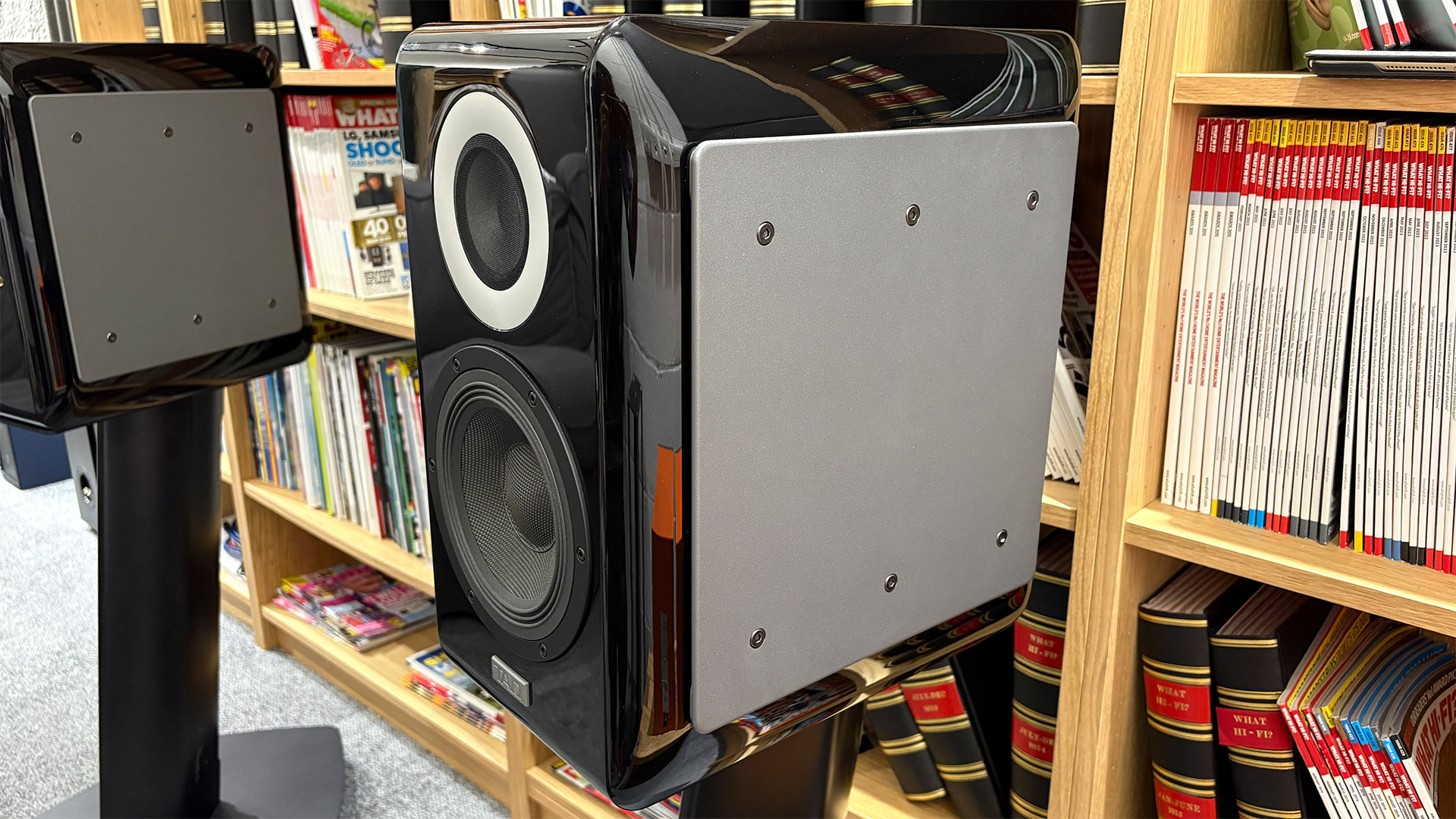 TAD ME1TX standmount speakers on stands in front of bookcase