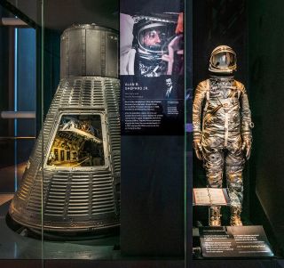 Alan Shepard's Mercury-Redstone 3 pressure suit (at right) and his Mercury spacecraft, "Freedom 7," in the "Destination Moon" gallery at the National Air and Space Museum in Washington. D.C.