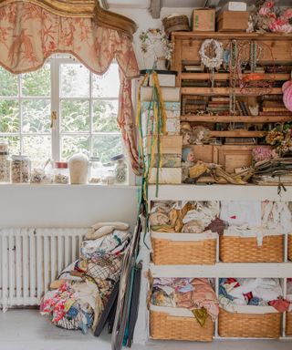 shelves and baskets filled with fabric and accessories in a cottage sewing room