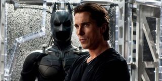 Christian Bale's Bruce with the Batman costume in the background