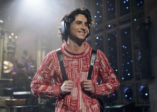 Timothee Chalamet in a red sweater and headphones doing a monologue on snl