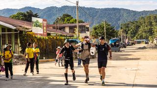 Ultra runners celebrate after running across the jungle