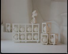 white sculptures by Simone Bodmer Turner on gridded shelves