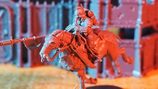 Death Rider in front of model barricades, bathed in red light