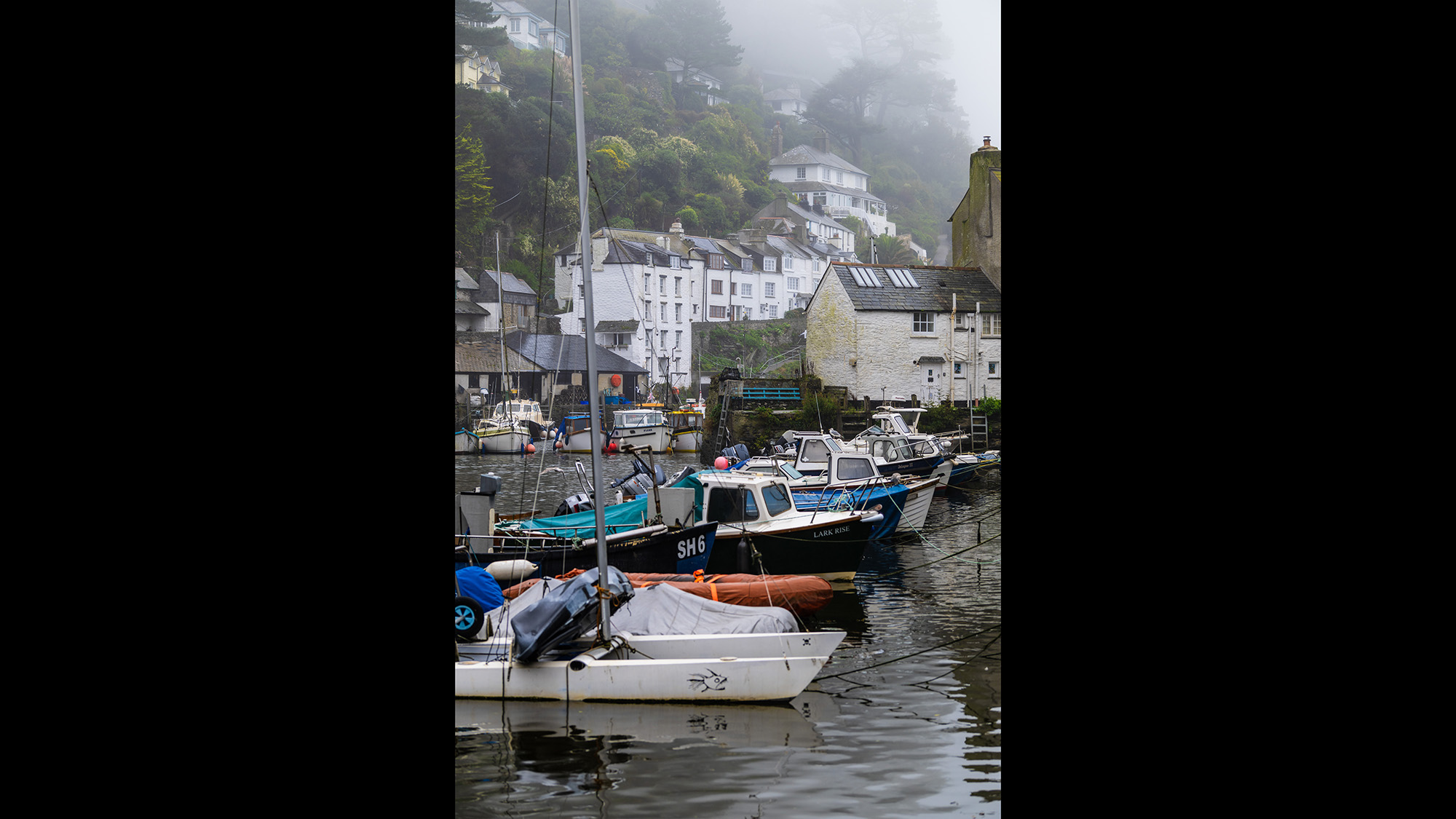 Boats in a harbour on a gloomy, misty morning