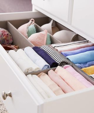 Open drawer with dividers between clothes