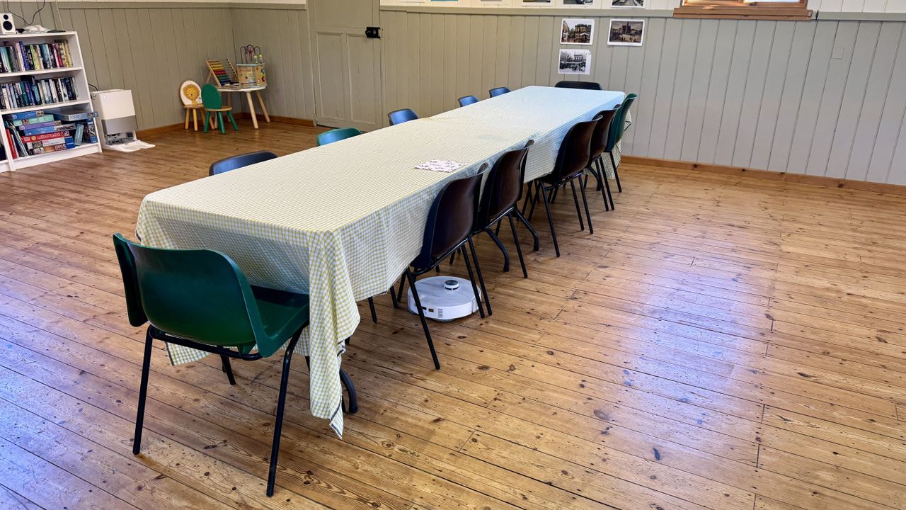Roborock Qrevo Master robot vacuum cleaning under a large table