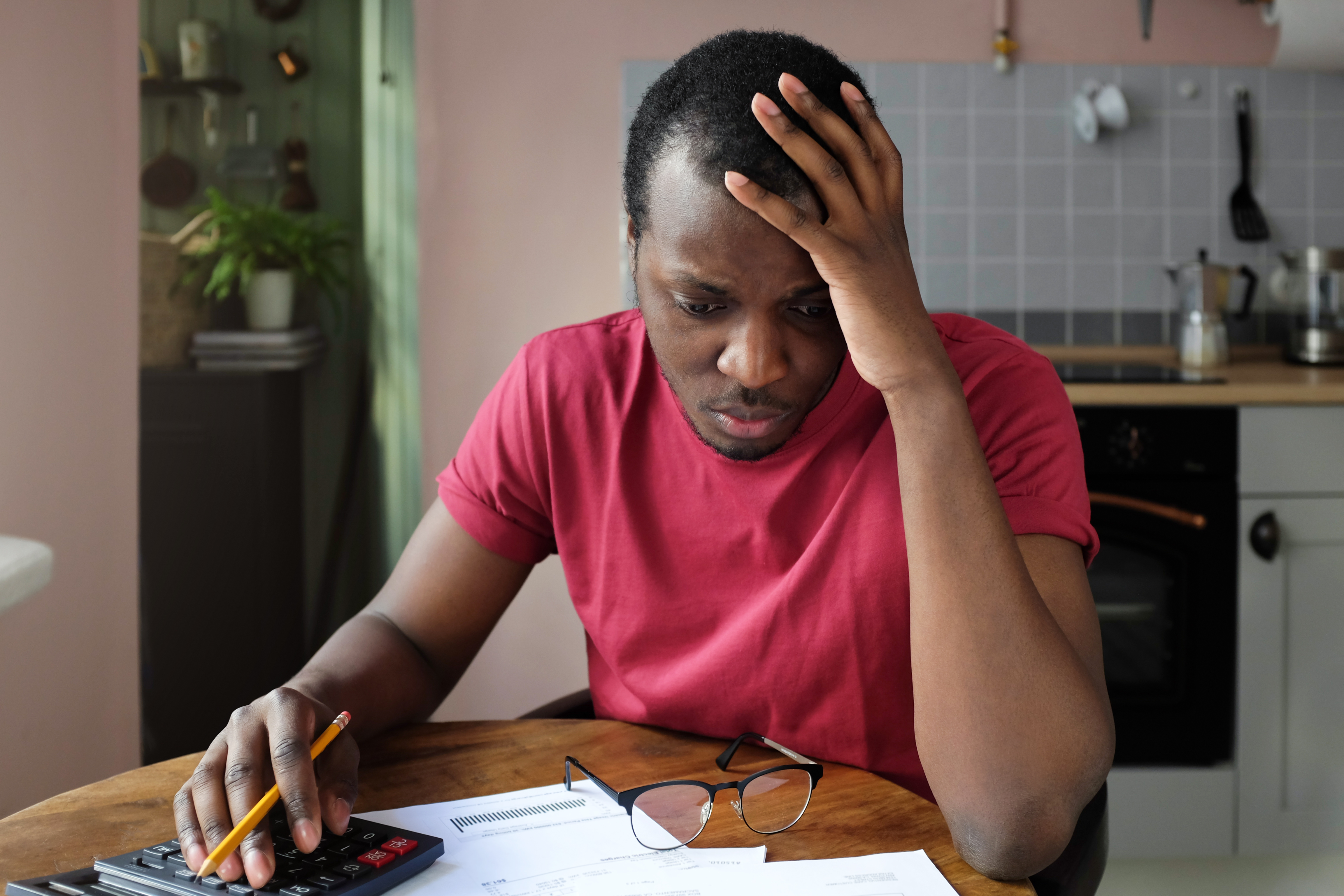 Man looks at savings documents beside calculator.