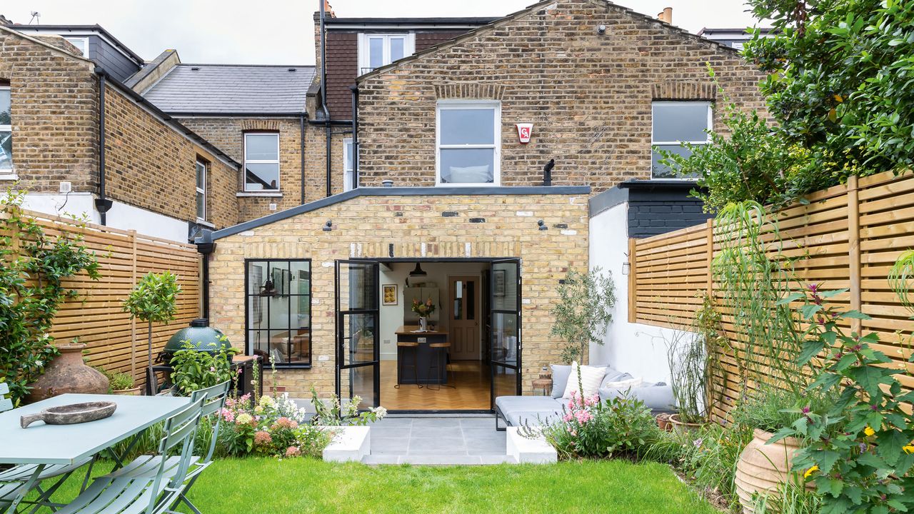 flat roof extension rear exterior of a house with a garden and patio doors