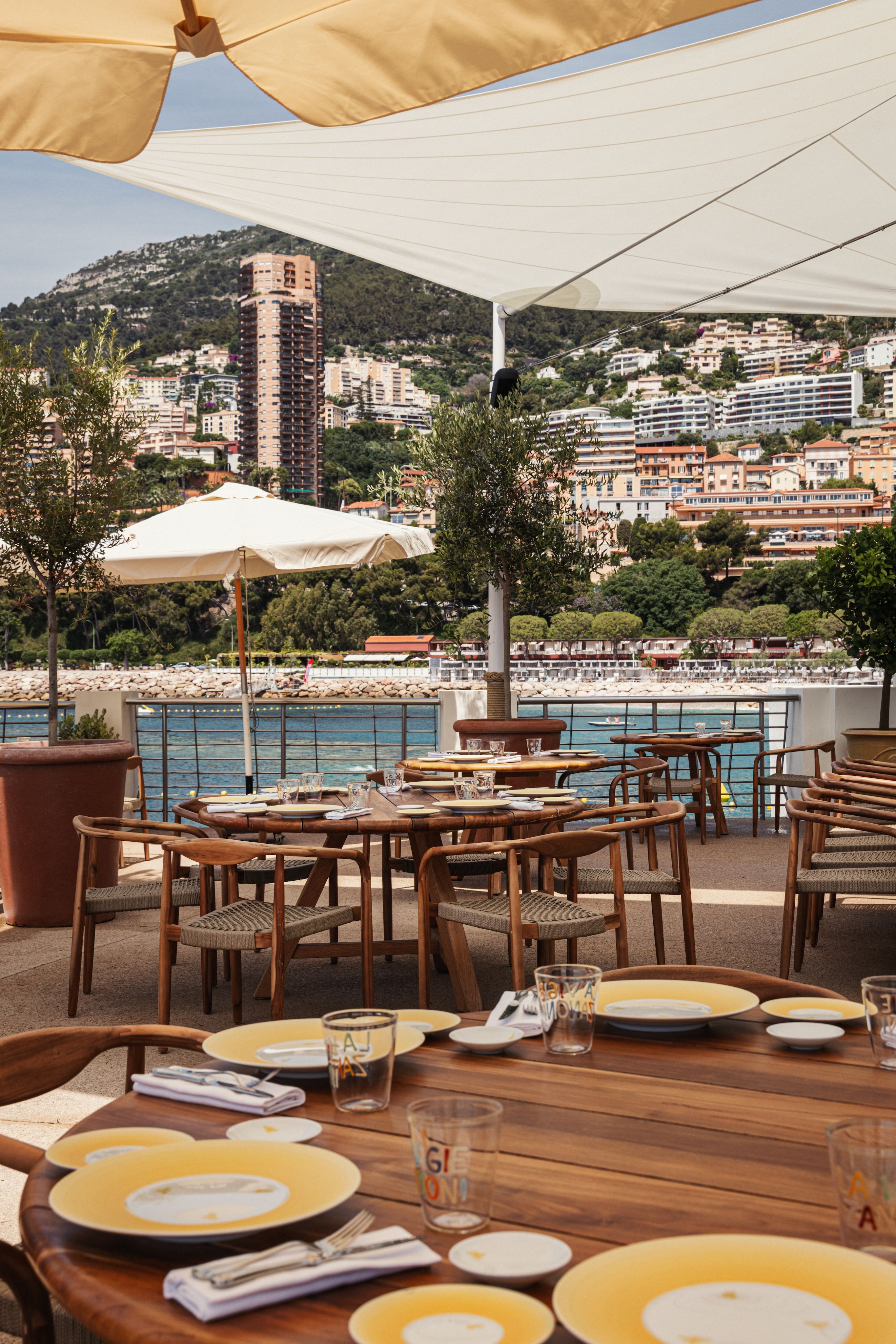 An outdoor restaurant with yellow-rimmed plated in Monaco