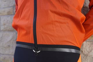 Image shows a cyclist wearing the Assos Equipe RS Rain Jacket Targa.