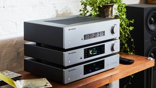 Cambridge Audio CXC, CXN V2 and CXA81 products stacked on top of eachother on a table