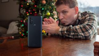 Looking greedily at the Moto G Power (2022) with Christmas Tree in the background