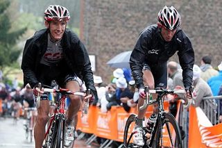 The Schleck brothers, Andy and Frank, cruise into the finish after a soggy day of racing.