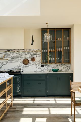 devol kitchen with marble backsplash and dark green kitchen cabinets