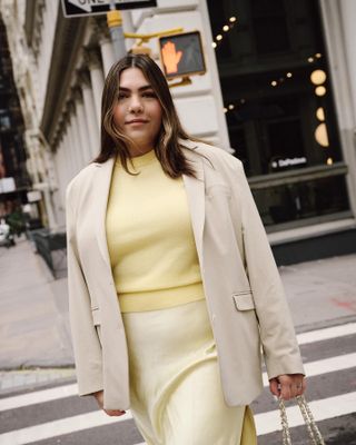 Ana wears butter yellow top and skirt with tan blazer.