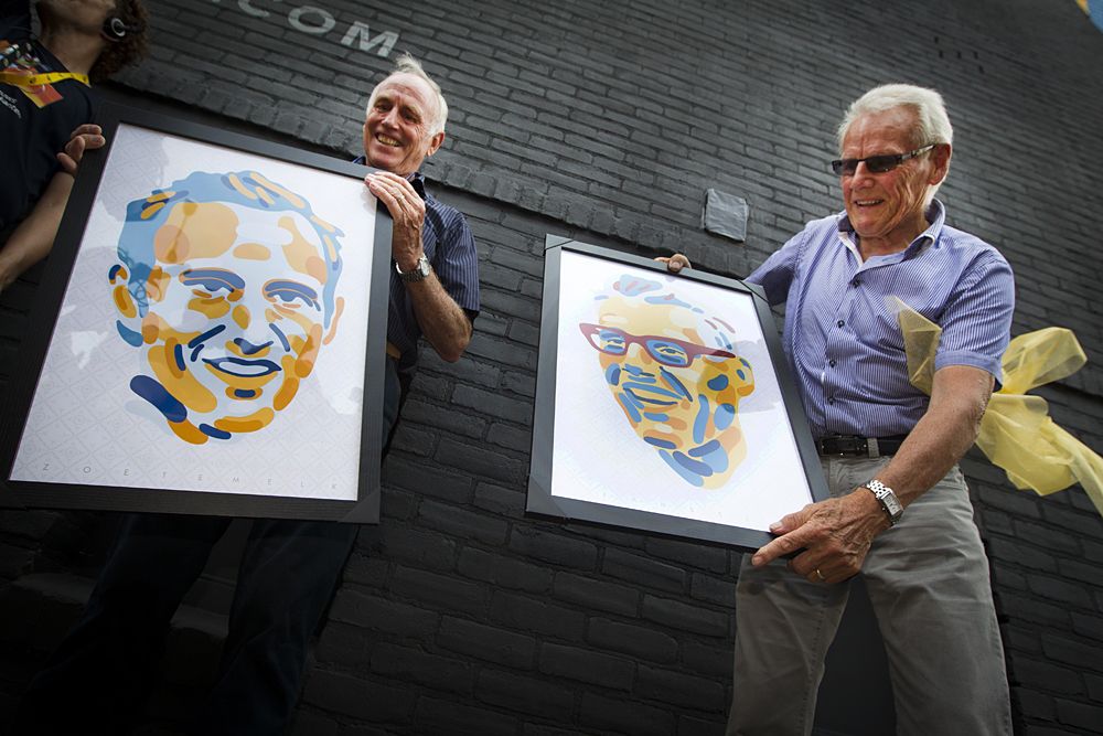 Former international Dutch cyclists Jan Janssen (R) and Joop Zoetemelk hold paintings of themselves as they unveil a mural depicting their portrait, along the route of the Tour de France in Utrecht, The Netherlands.
