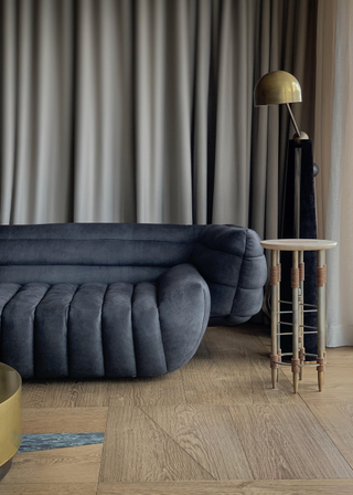 A wabi-sabi living room with a blue couch and a wood side table