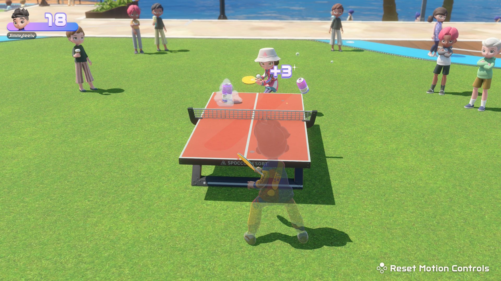 A screenshot showing a person hitting cans while playing table tennis in Nintendo Switch Sports Resort
