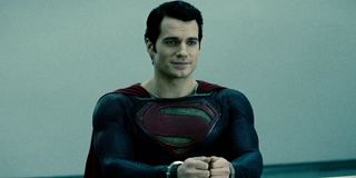 Man of Steel Superman smiling, as he sits cuffed in an interrogation cell