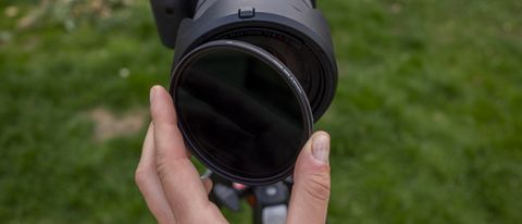The Kenko Pro1D Variable ND filter being screwed onto a Canon lens