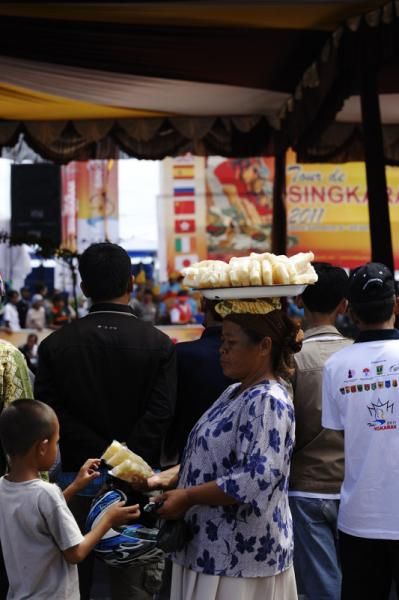 A woman sells pineapple for a child