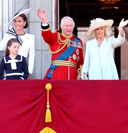 Members of the royal family including The King, Queen, Kate Middleton and Princess Charlotte on the Buckingham Palace balcony smiling and waving during Trooping the Colour 