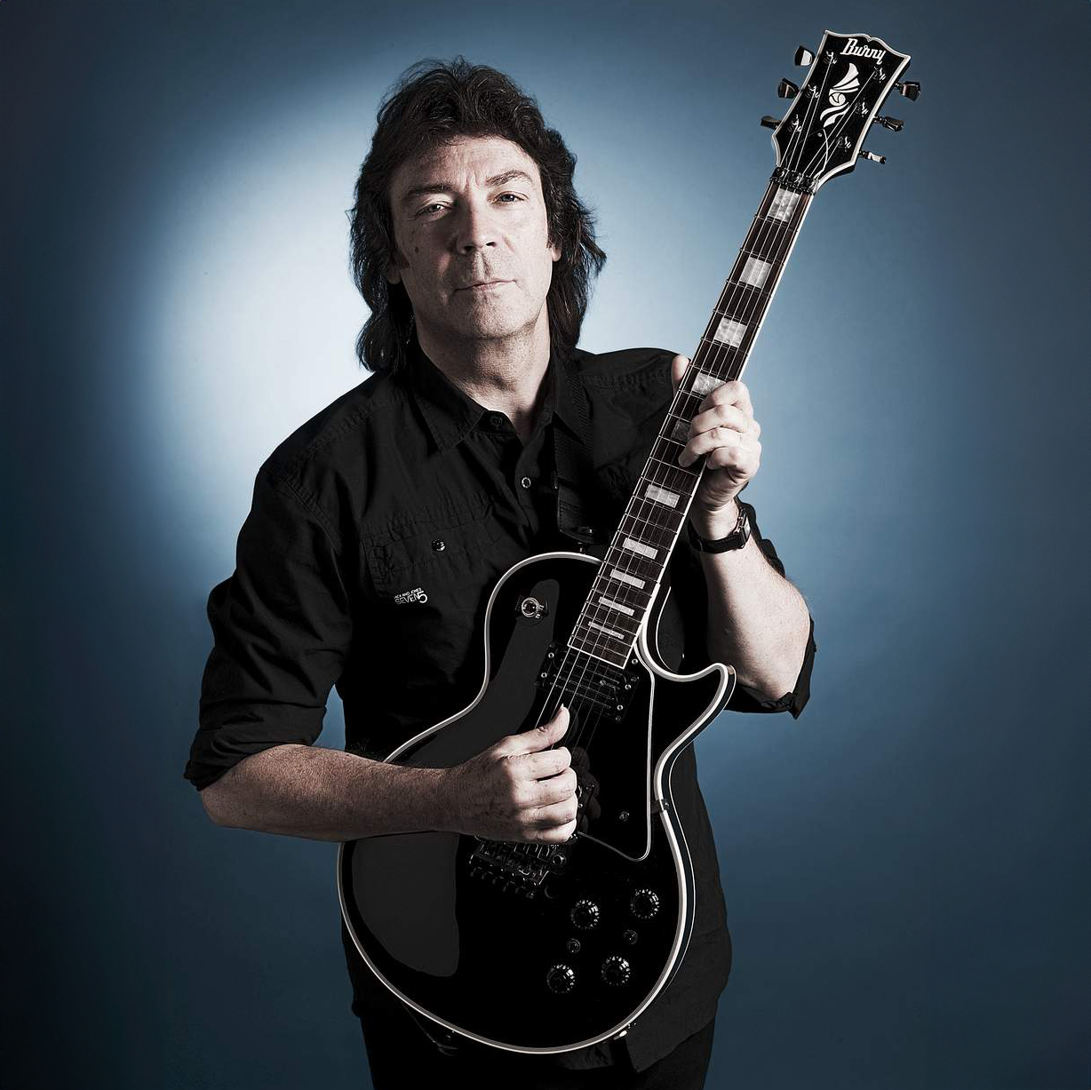 Portrait of British singer-songwriter Steve Hackett, former Genesis and GTR guitarist and prolific solo performer, posing with his Fernandes Les Paul Black guitar on August 24, 2011