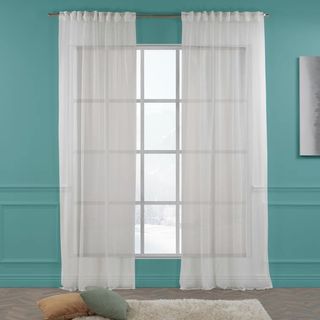A sash window with a pair of voile curtains