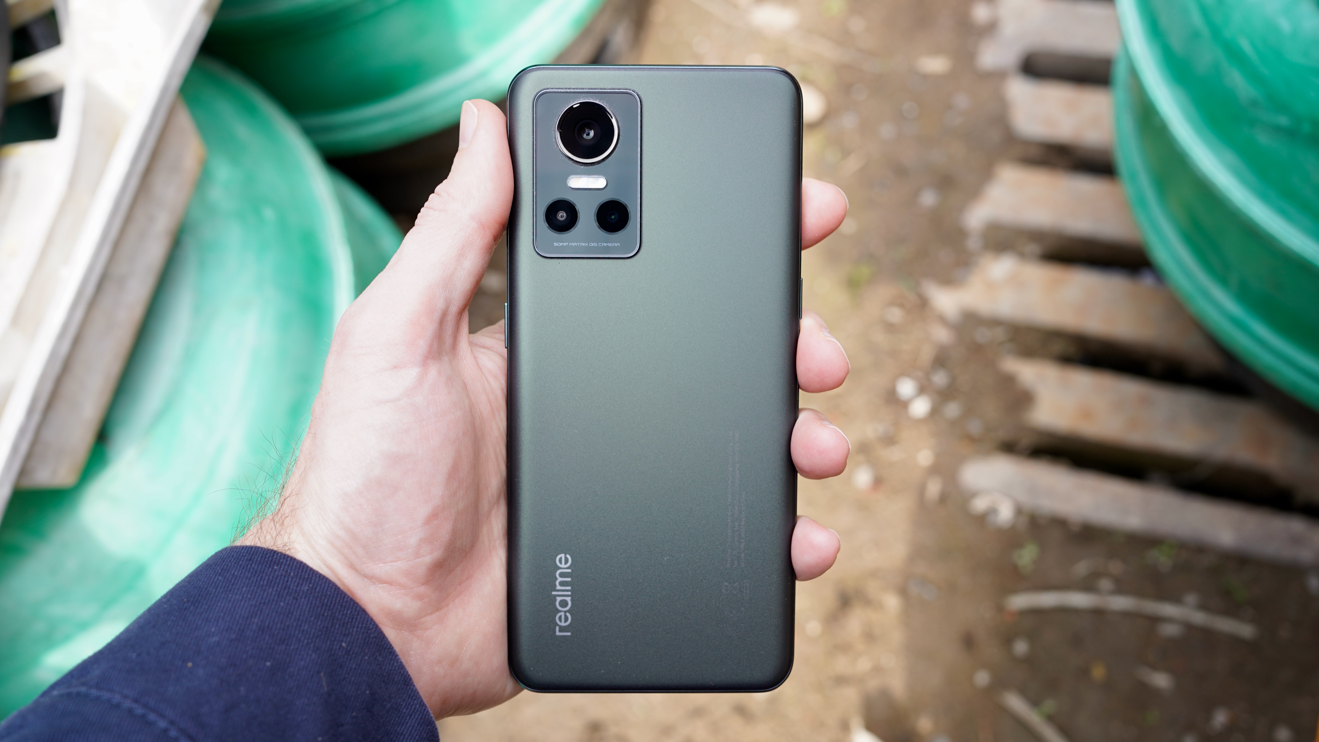A Realme GT Neo 3 from the back in someone's hand