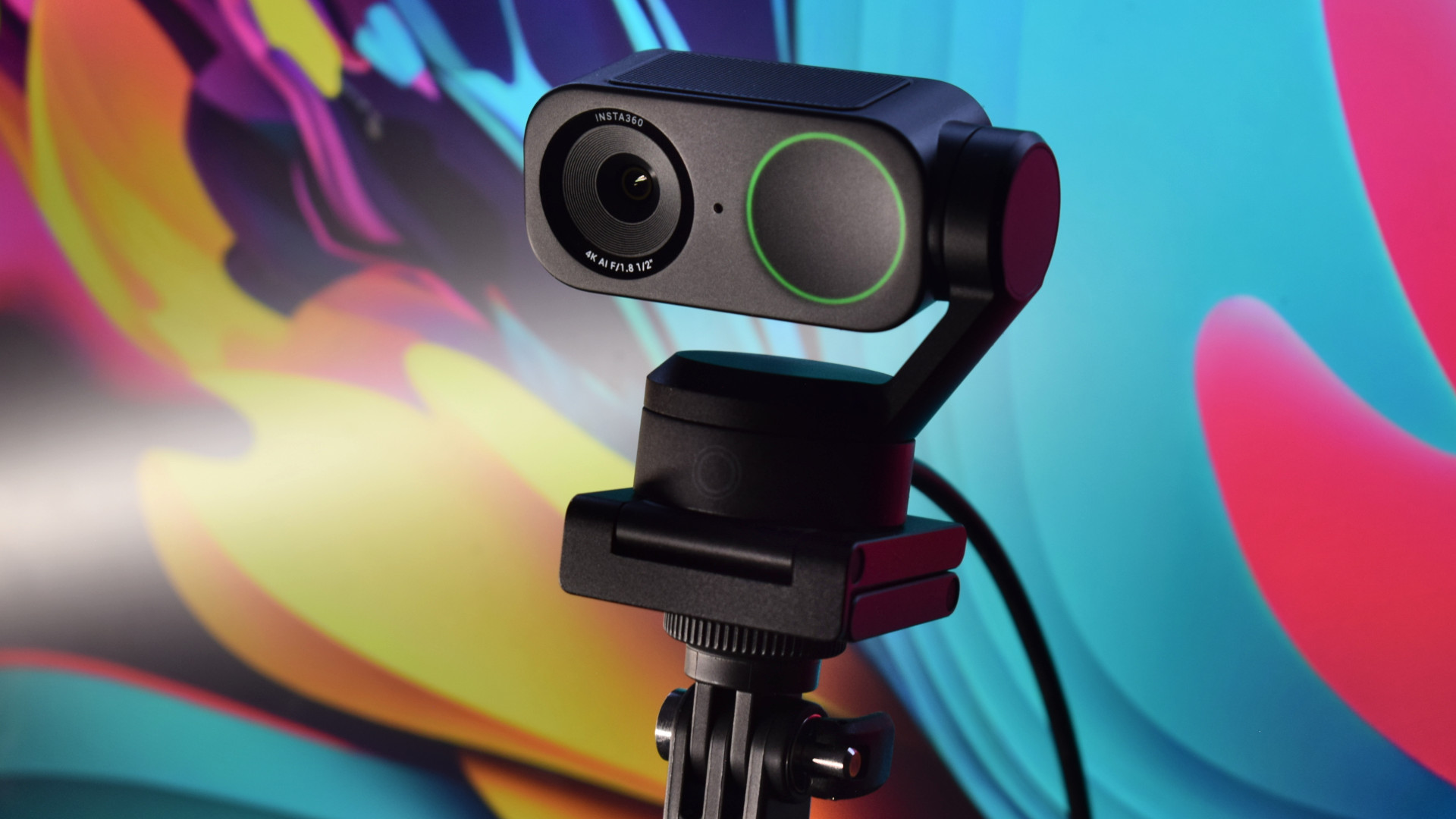 Photo of the Insta360 Link 2 4k webcam showing the camera's Magnetic Mount being used on a tripod.